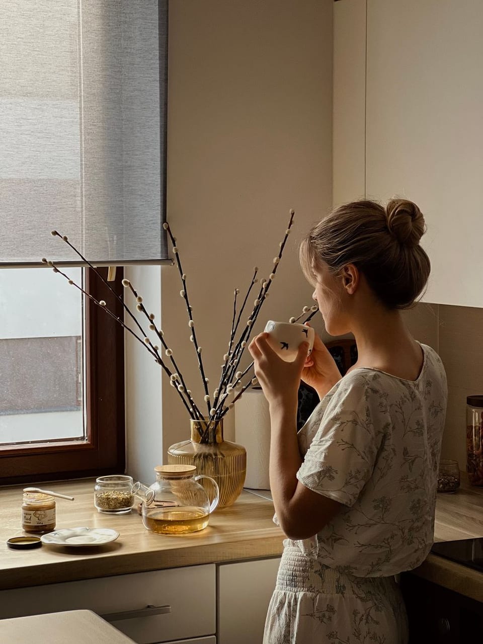 A woman with a mug by the window